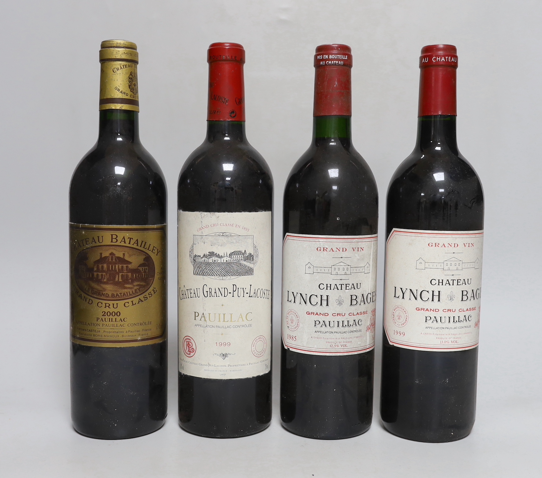 Four bottles of wine: one bottle of 75cl 1985 and one bottle of 75cl 1999 Chateau Lynch Bages Grand Cru Classé Pauillac, one bottle of 75cl 1999 Château Grand-Puy-Lacoste Pauillac, and one bottle of 75cl 2000 Château Bat